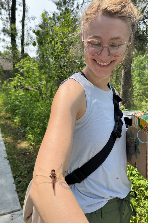 Myra McKee smiling at a dragonfly that landed on her arm