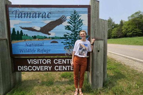 Myra McKee standing in front of the Tamarac National Wildlife Refuge welcome sign