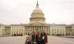 Four teens standing in front of the U.S. Capitol building.